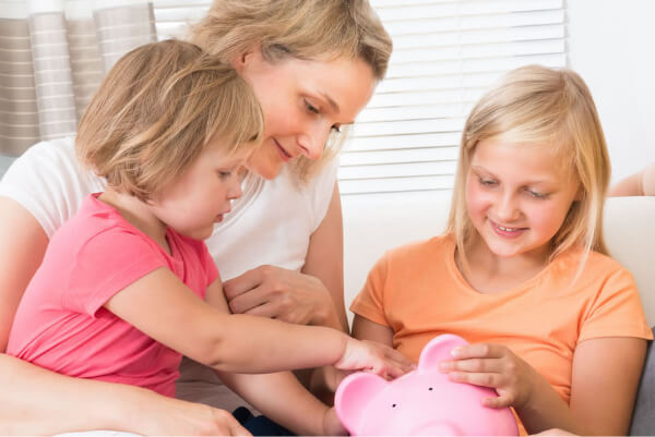 Family putting money into a savings jar